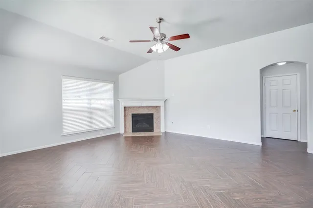 an empty room with fan and windows