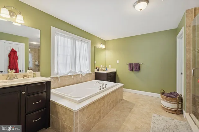 a bathroom with a tub sink and mirror