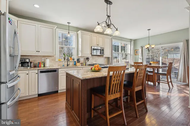a kitchen with a dining table chairs and white cabinets