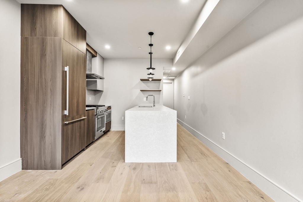 300 Franklin Street, Unit 2 Cambridge, MA 02139 - Photo 7 of 17 a kitchen with kitchen island a counter top space a sink stainless steel appliances and cabinets