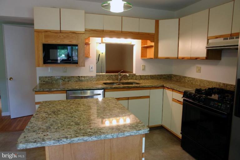 2440 Alsop Court Reston, VA 20191 - Photo 7 of 21 a kitchen with kitchen island granite countertop a stove a sink and a microwave