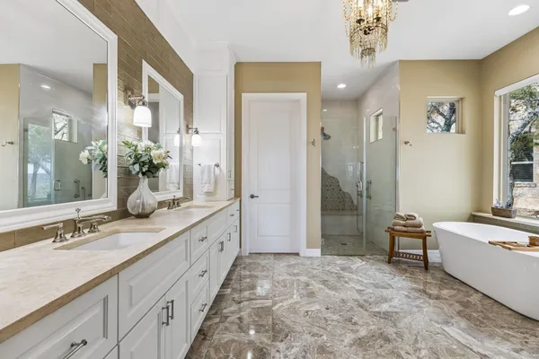 a spacious bathroom with a double vanity sink a mirror and a shower
