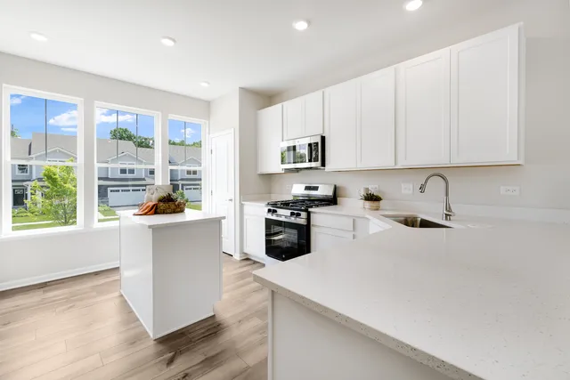 a kitchen with a sink a stove and white cabinets