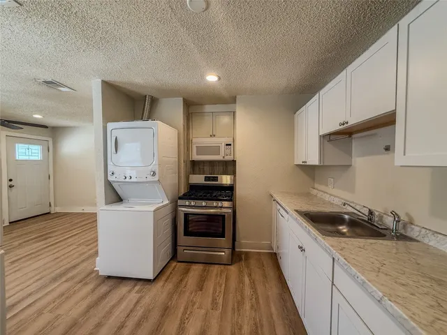 a kitchen with granite countertop a sink and a stove top oven