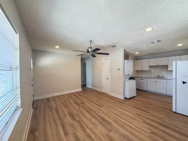 a view of a kitchen with a sink and dishwasher a refrigerator with wooden floor