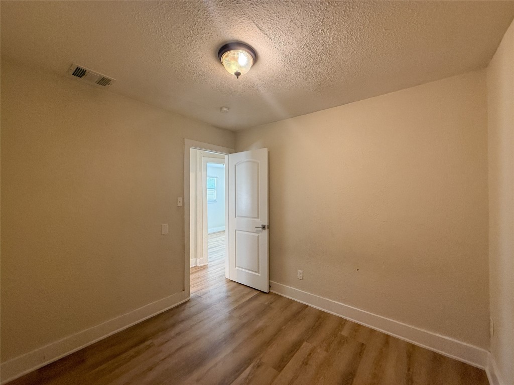 1412 Vargas Road, Unit A Austin, TX 78741 - Photo 25 of 32 a view of an empty room with wooden floor and a window