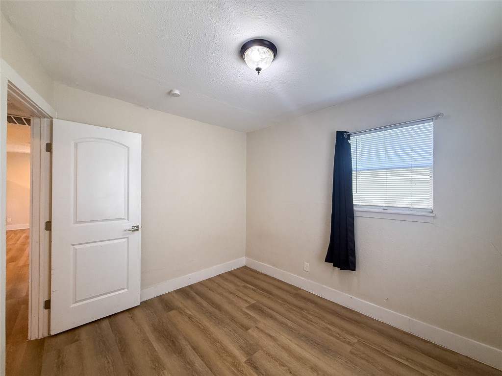 1412 Vargas Road, Unit A Austin, TX 78741 - Photo 29 of 32 a view of an empty room with wooden floor and a window