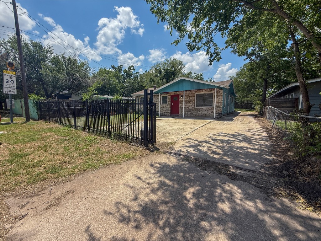1412 Vargas Road, Unit A Austin, TX 78741 - Photo 8 of 32 a backyard of a house with large trees and a wooden fence