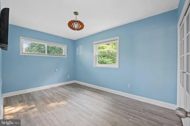 an empty room with wooden floor and window