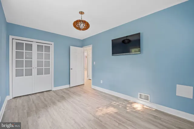 a view of empty room with wooden floor and window