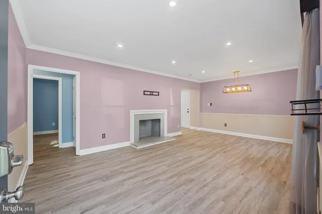 a view of empty room with wooden floor and fireplace