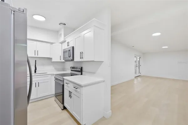 a kitchen with stainless steel appliances a white stove top oven sink and cabinets