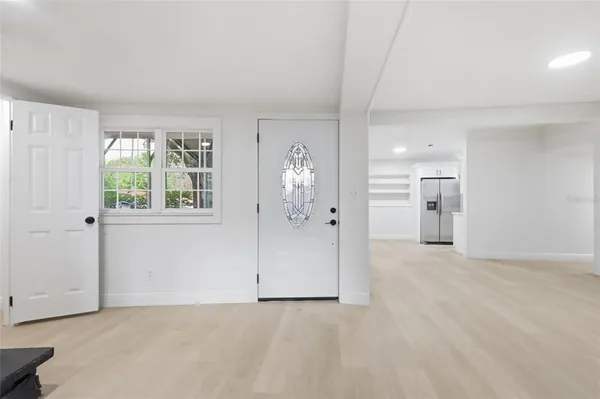 a view of a big room with windows and chandelier fan