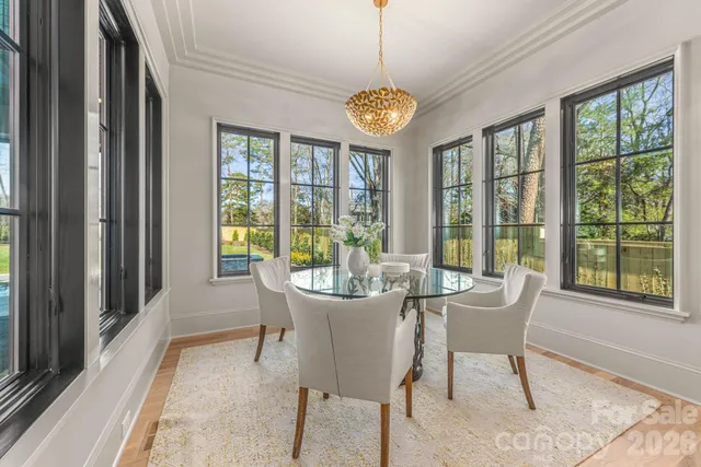 a view of a dining room with furniture a chandelier and wooden floor