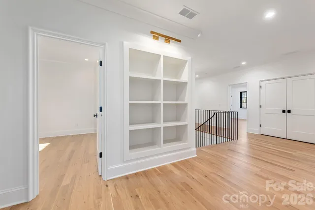 a view of empty room with wooden floor