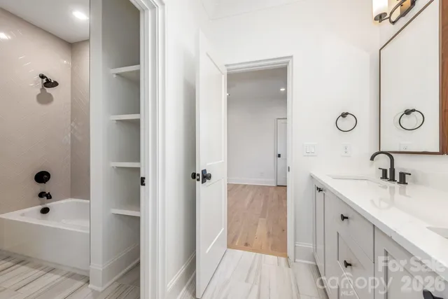 a bathroom with a tub sink and mirror