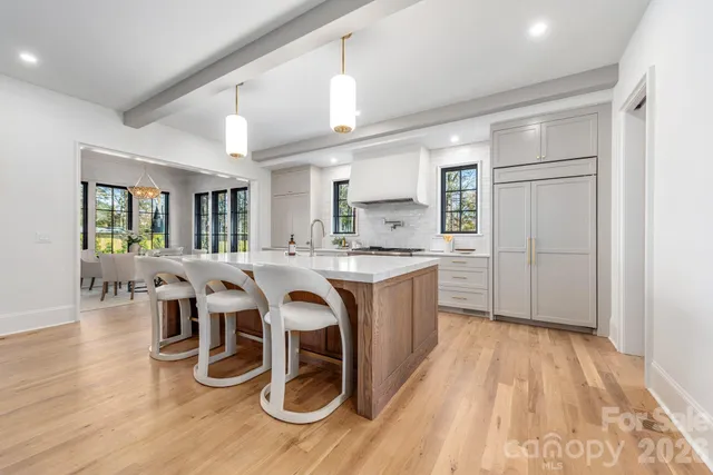 a kitchen with stainless steel appliances granite countertop a sink and wooden floor