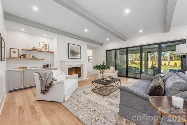 a living room with furniture a large window and a fireplace