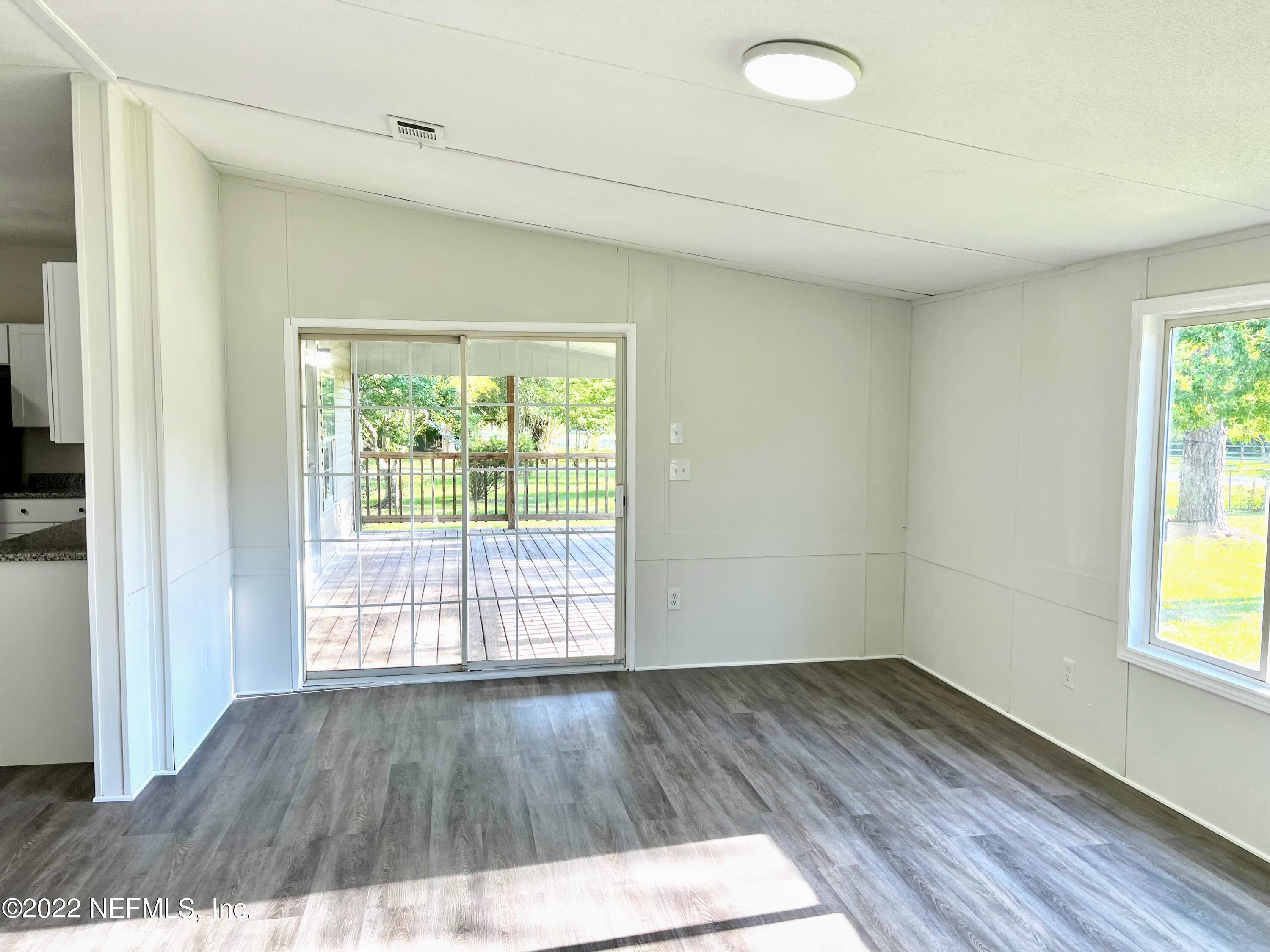 54176 Armstrong Road Callahan, FL 32011 - Photo 14 of 30 an empty room with wooden floor and windows