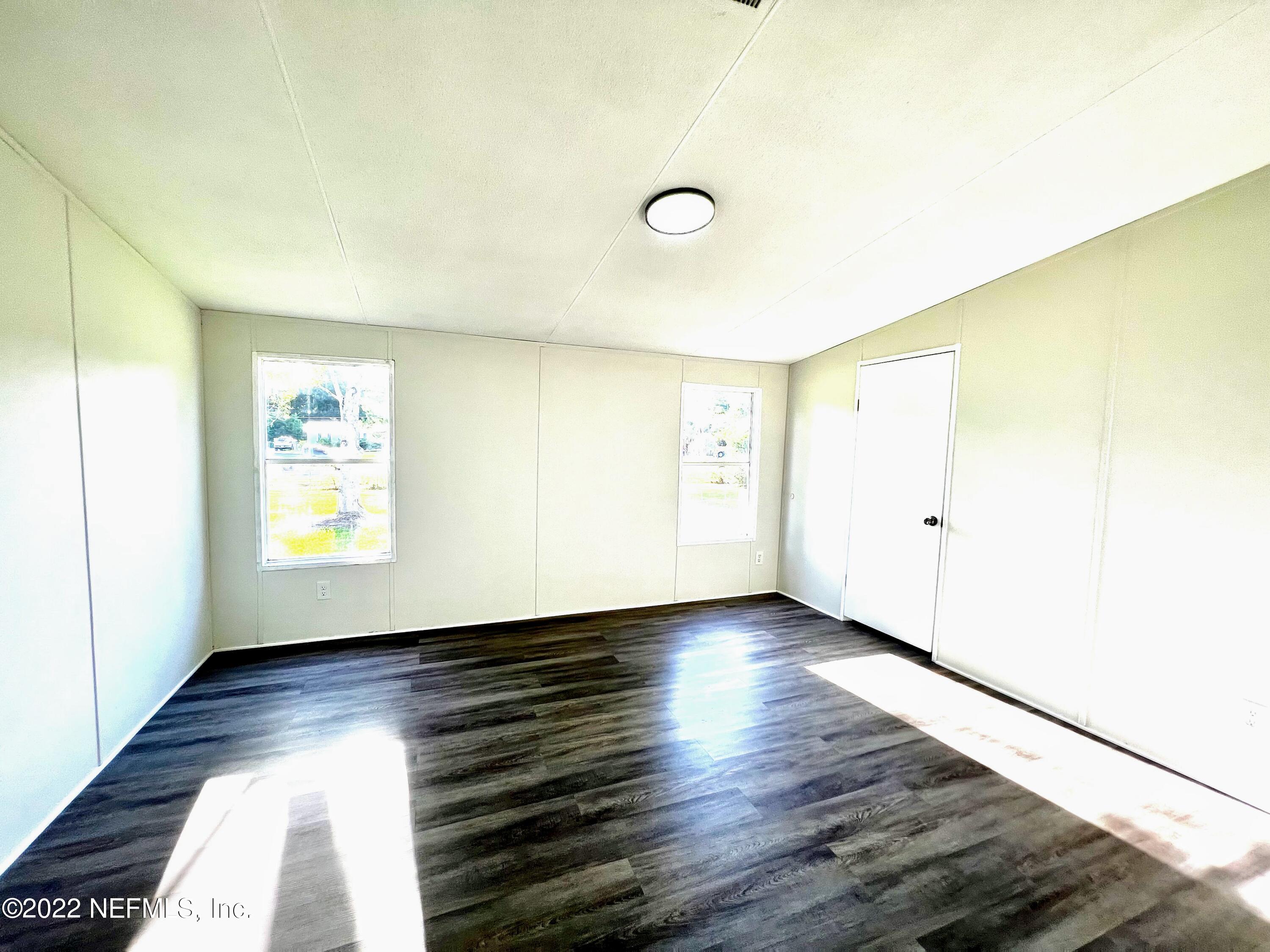 54176 Armstrong Road Callahan, FL 32011 - Photo 16 of 30 a view of an empty room with wooden floor and a window
