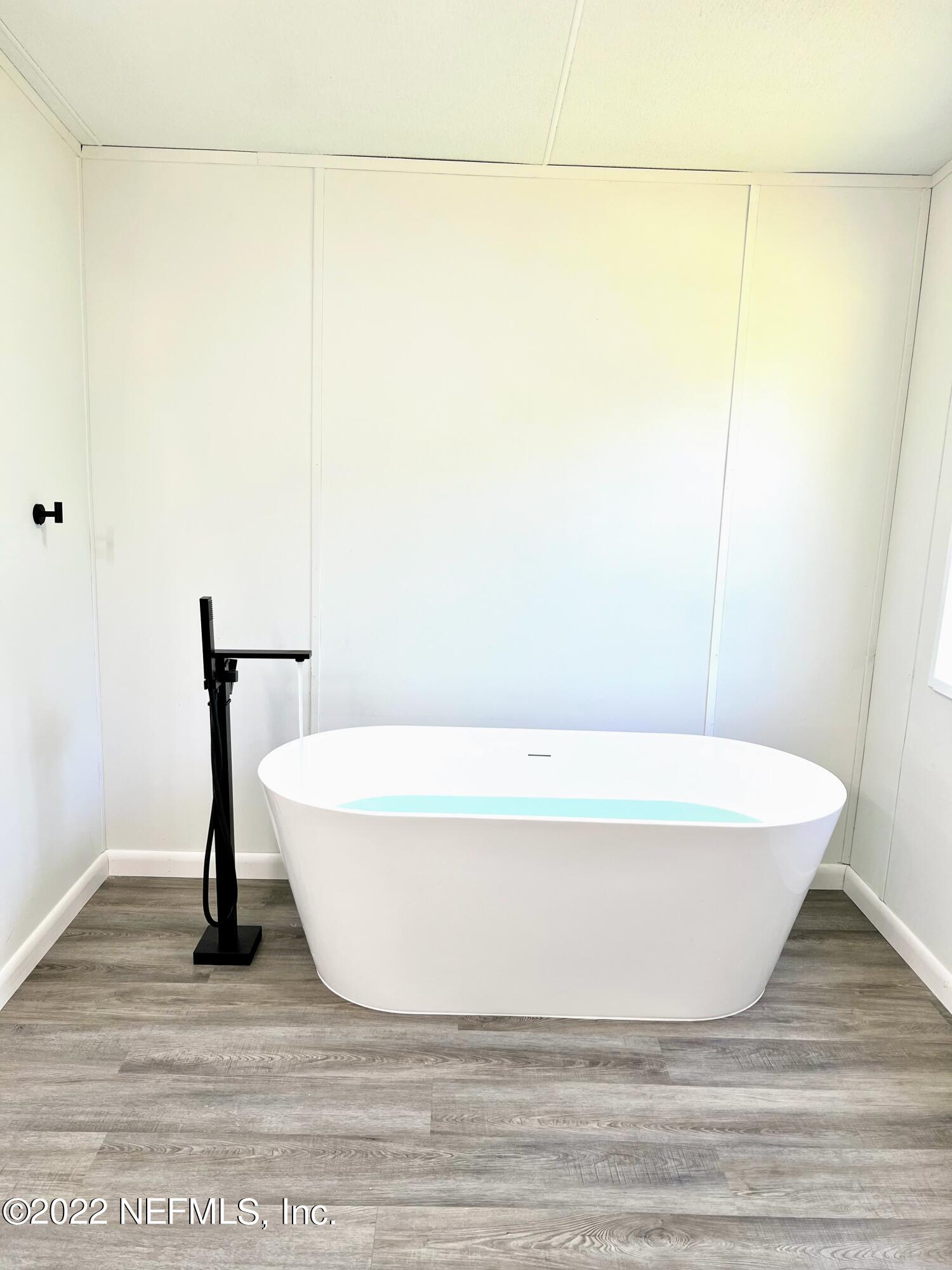 54176 Armstrong Road Callahan, FL 32011 - Photo 19 of 30 a white bath tub sitting next to a white sink and vanity