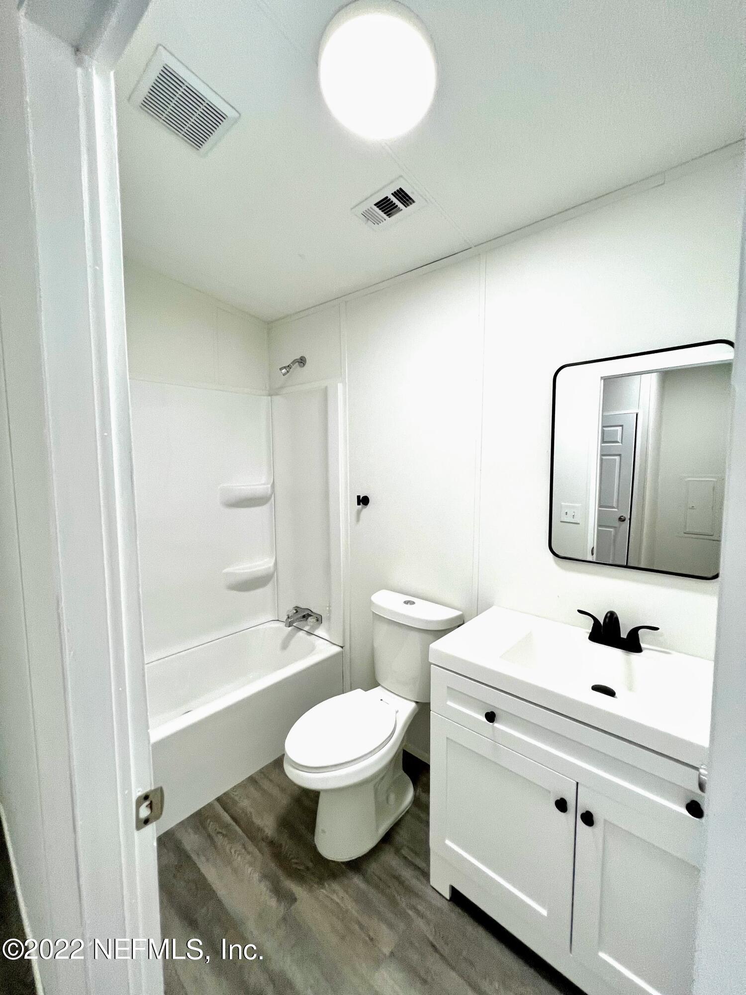 54176 Armstrong Road Callahan, FL 32011 - Photo 24 of 30 a bathroom with a sink a toilet and a mirror