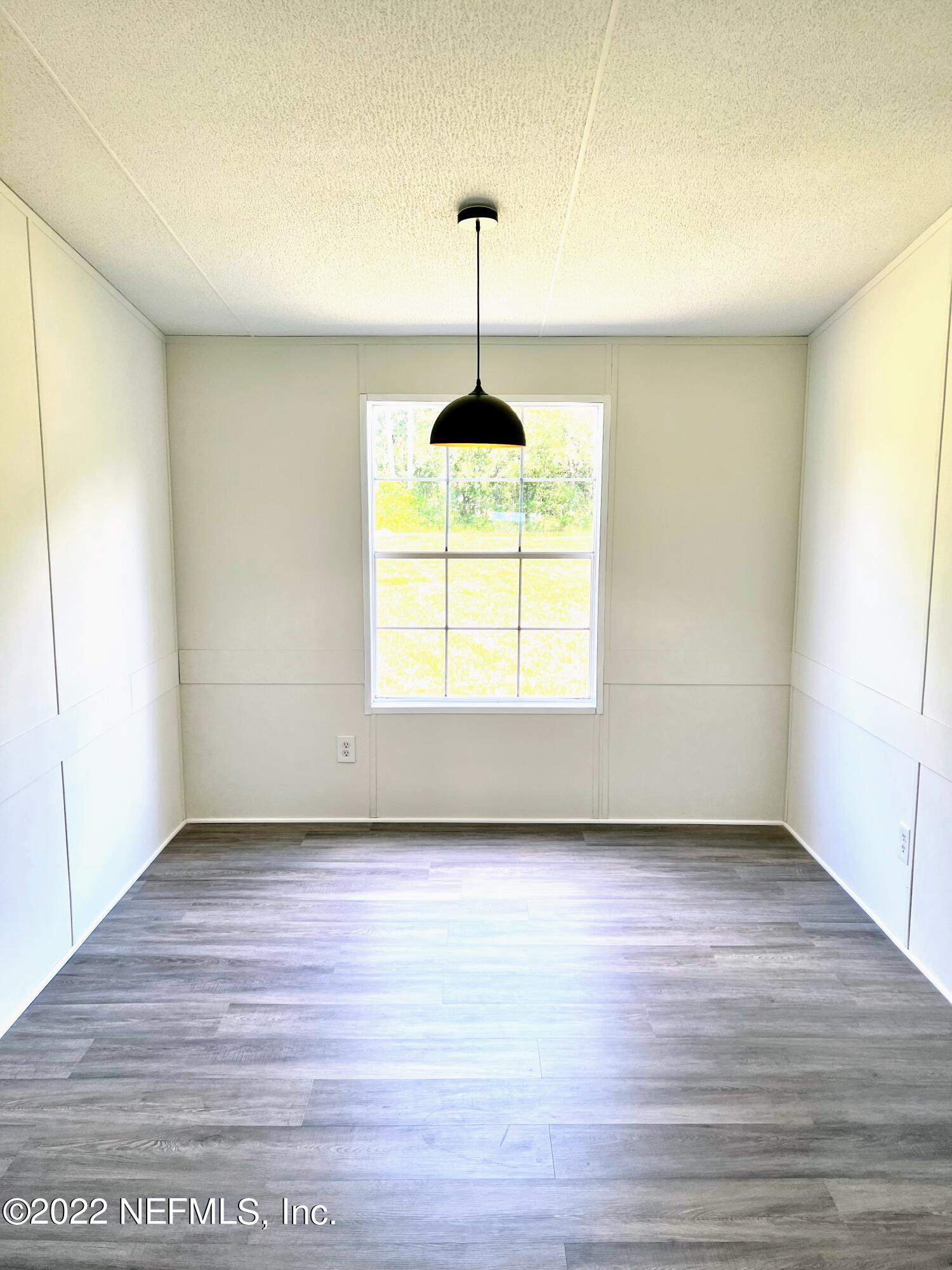 54176 Armstrong Road Callahan, FL 32011 - Photo 8 of 30 a view of empty room with wooden floor and fan