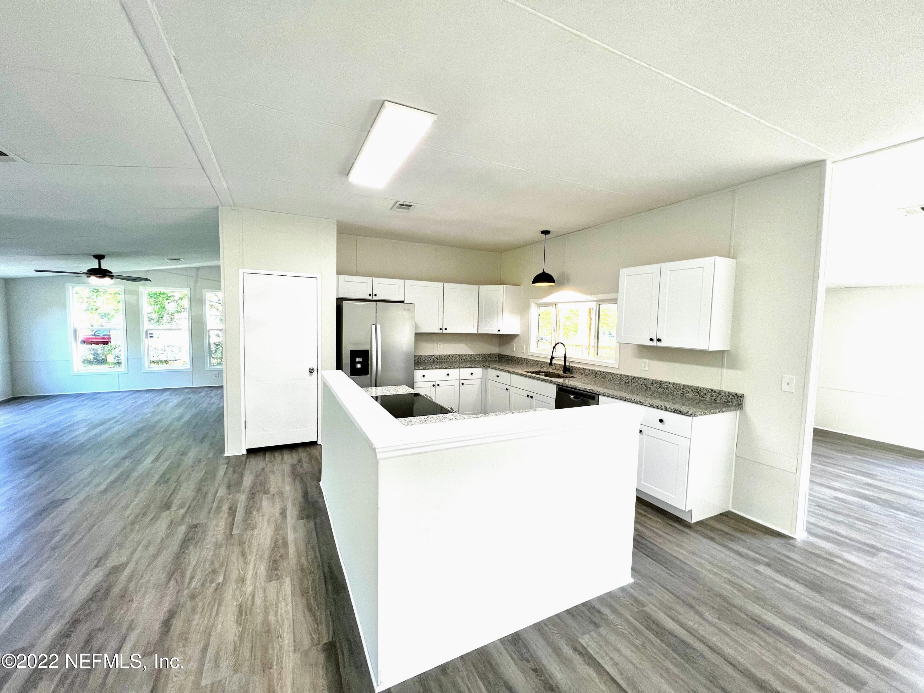 54176 Armstrong Road Callahan, FL 32011 - Photo 10 of 30 a large white kitchen with a white countertops a stove and a wooden floors