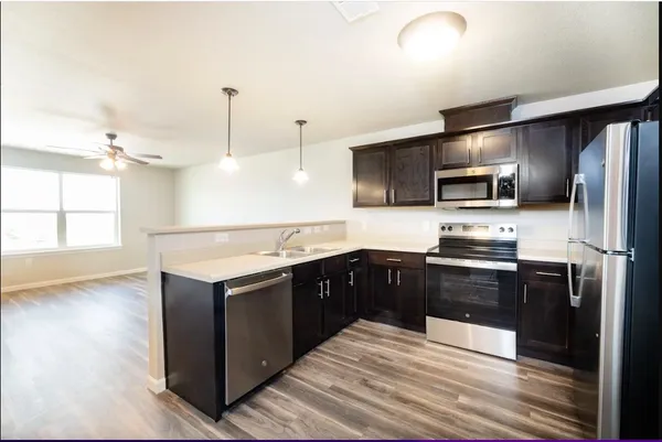 a modern kitchen with stainless steel appliances and wooden cabinets