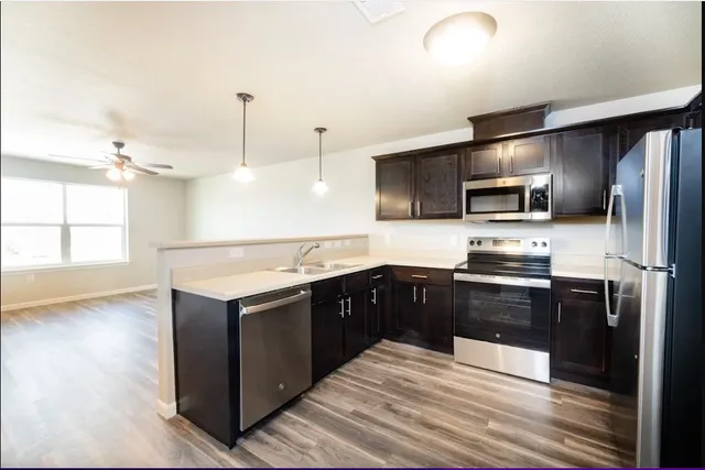a modern kitchen with stainless steel appliances and wooden cabinets