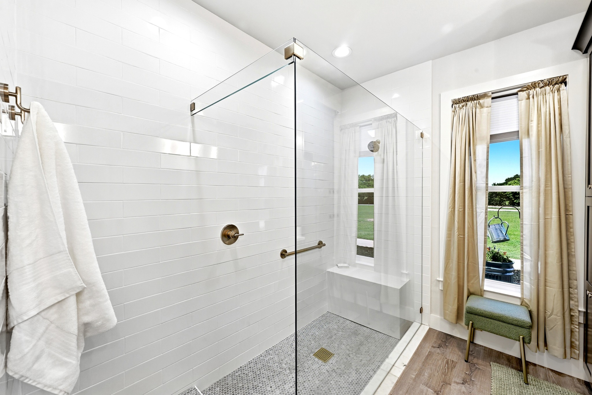2889 Old McMahan Road Lockhart, TX 78644 - Photo 21 of 33 A well-lit primary bathroom with sleek shower tiles and rich wood flooring creates a serene escape.