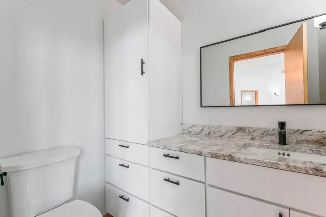 a bathroom with a toilet sink and mirror