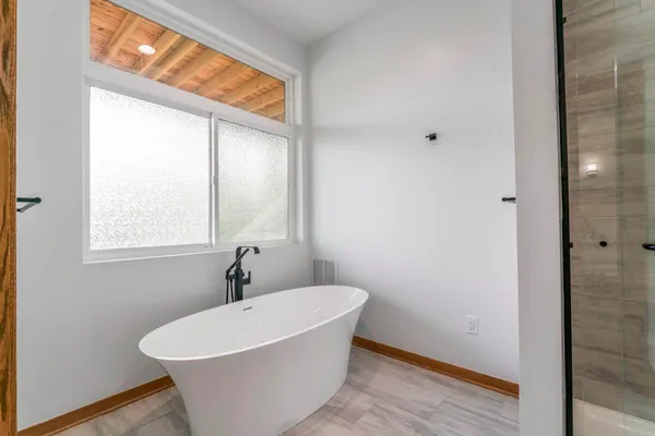 a bathroom with a toilet a sink a tub and mirror