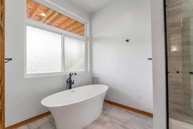 a bathroom with a toilet a sink a tub and mirror