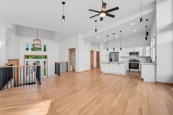 a view of a kitchen with refrigerator and wooden floor