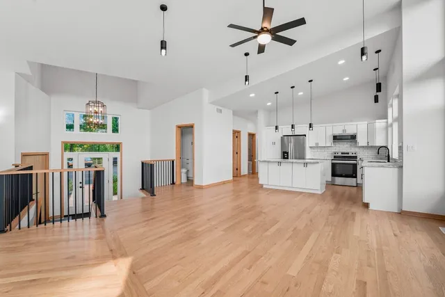 a view of a kitchen with refrigerator and wooden floor