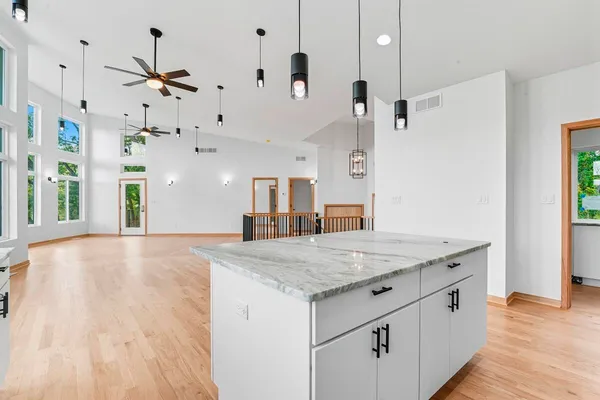 a kitchen with kitchen island a stove a sink and a wooden floor