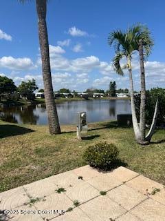 5361 Bison Street, Unit P19 Micco, FL 32976 - Photo 5 of 27 a view of a lake with a bench under a palm tree