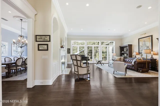 a dining room with furniture a chandelier and wooden floor