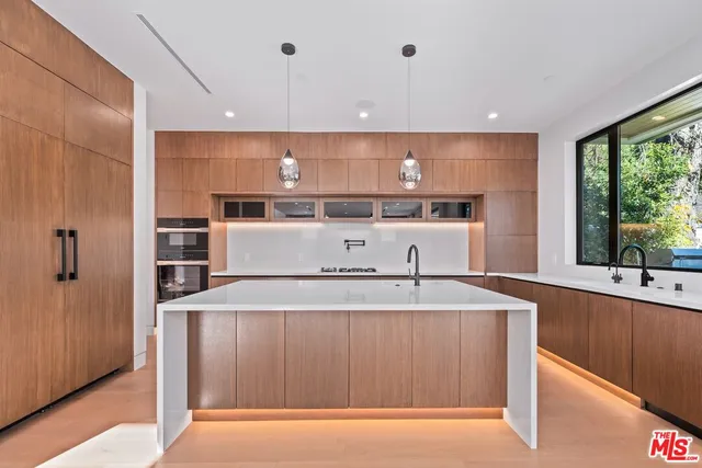 a view of staircase with lots of frames on wall and wooden floor