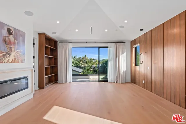 a view of empty room with wooden floor and windows