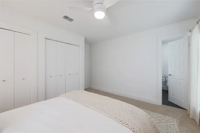 a bedroom with a bed and a lamp on the dresser