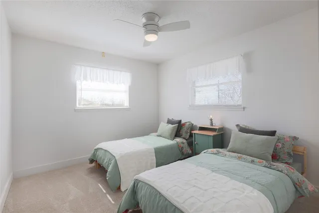 a bedroom with two beds and a chandelier