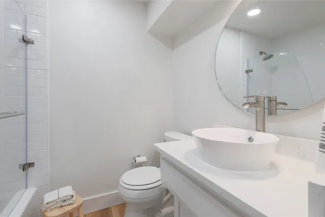 a bathroom with a sink a toilet and a mirror