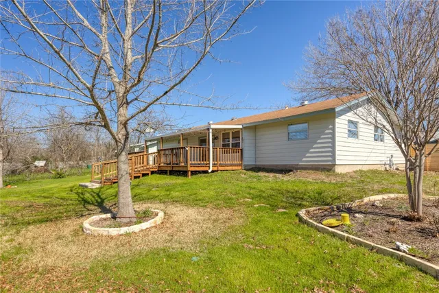 a backyard of a house with a garden and barbeque oven