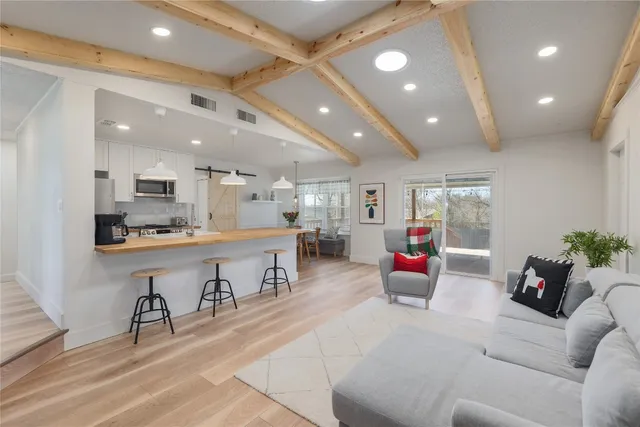 a living room with lots of furniture and kitchen view