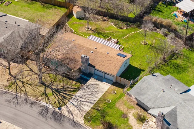 an aerial view of a house with a yard and swimming pool