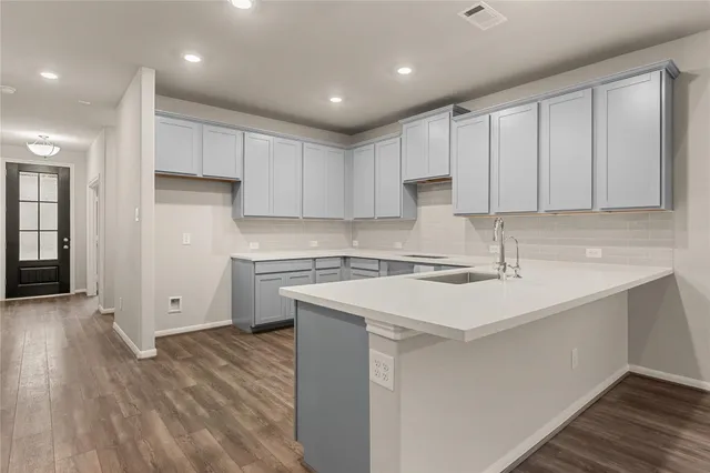 a kitchen with a sink window and cabinets