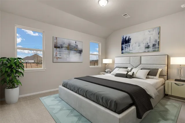 a bedroom with a large bed and a potted plant