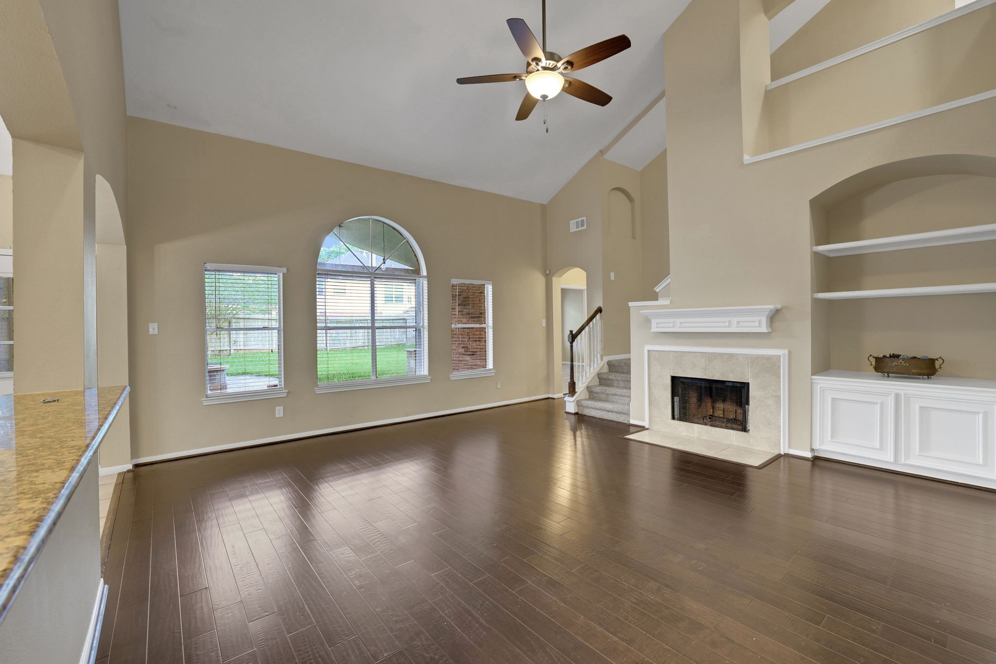 23207 Olive Ridge Court Katy, TX 77494 - Photo 15 of 46 an empty room with wooden floor fireplace and windows